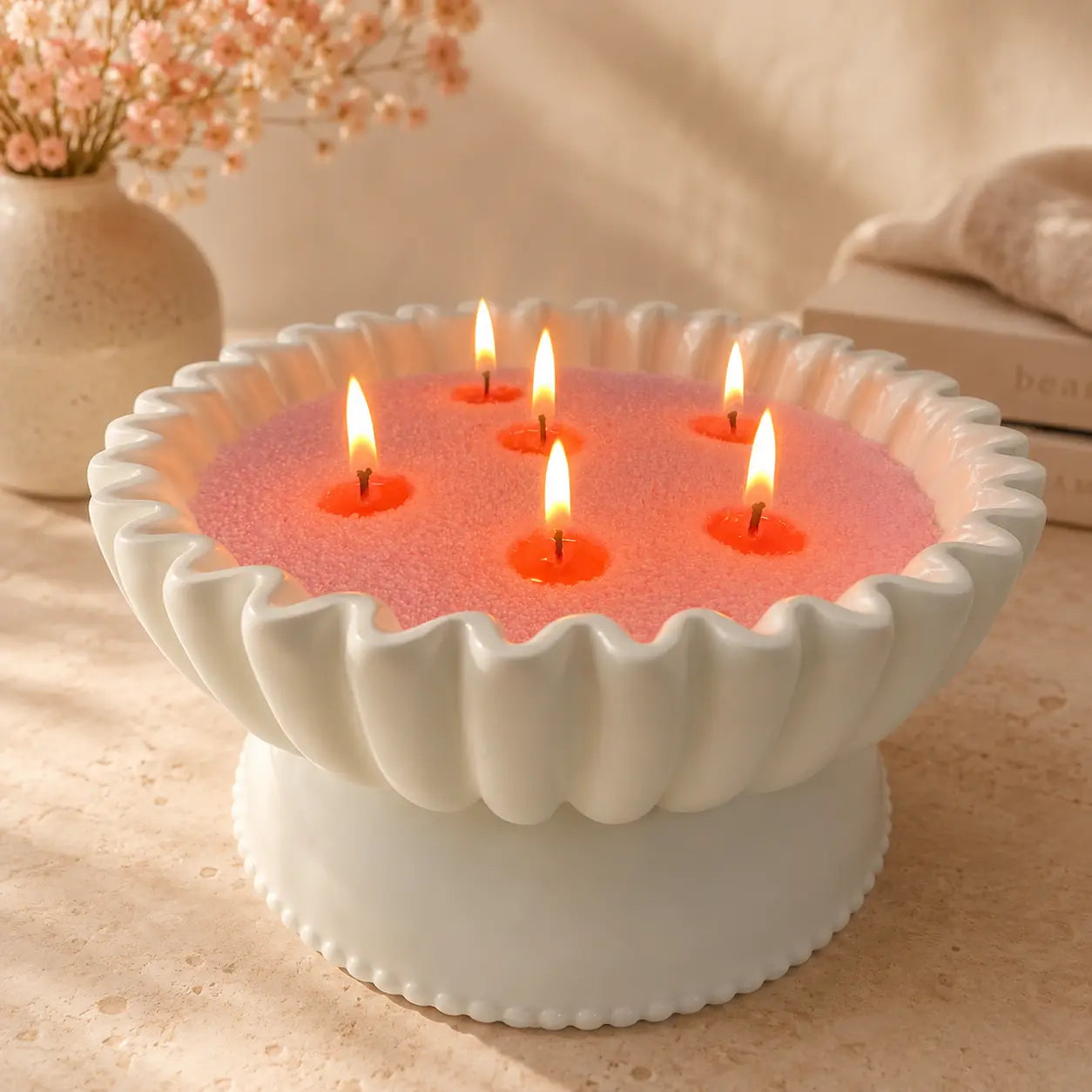 Blush Pink Pearled Candle Wax lit in a white scalloped candle vessel with warm glowing flames
