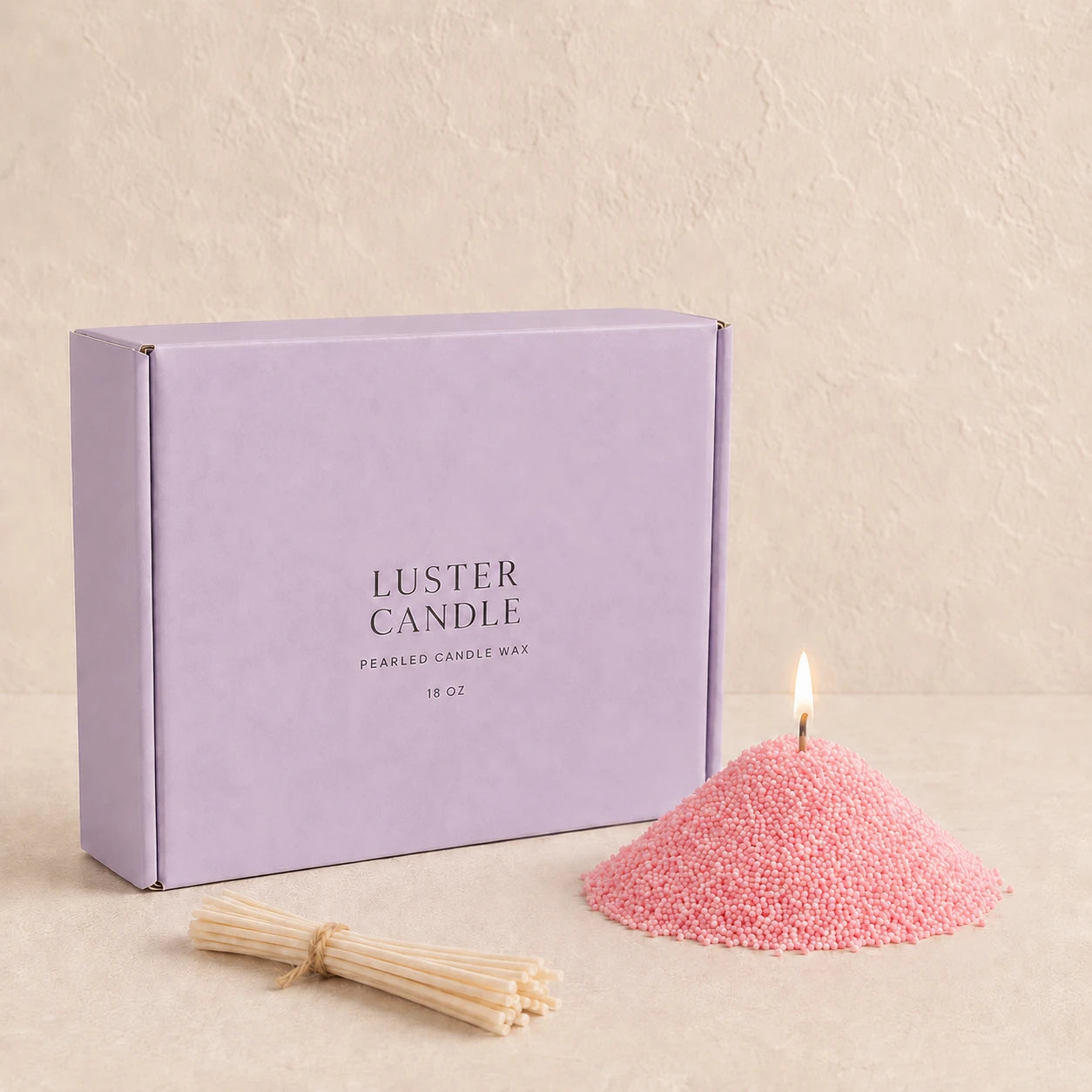 Blush Pink Pearled Candle Wax with lavender purple Luster Candle box, pearled candle wax mound, cotton wick bundle, and soft flame.