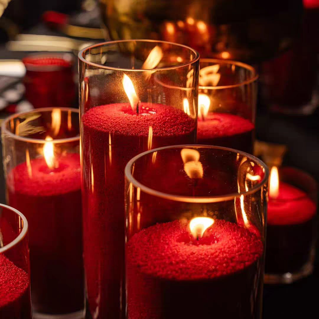 Clear glass candle vessels styled with red pearled candle wax for warm event and dinner decor.