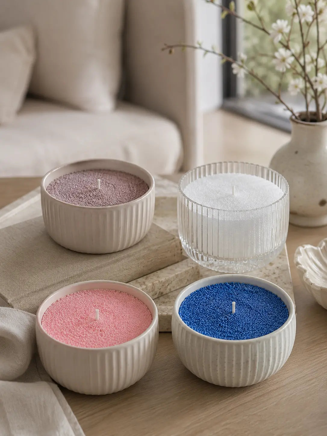 seasonal refillable pearled candle wax in blush pink, ocean blue, warm taupe, and soft white styled in modern home vessels.