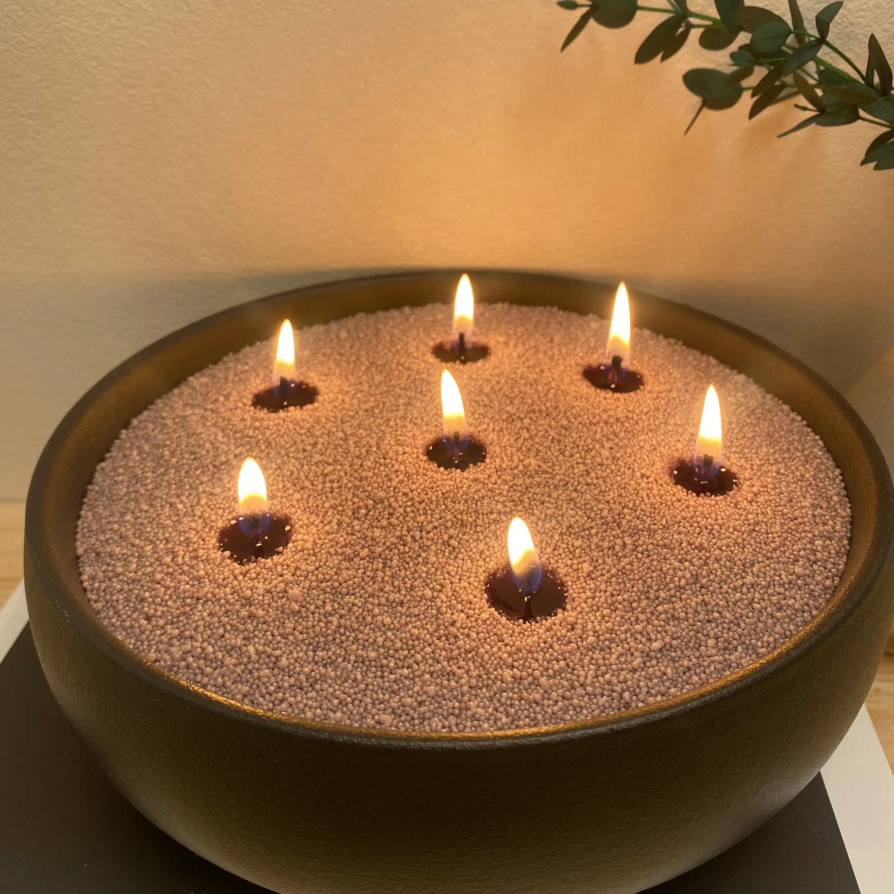 Mist Grey pearled candle wax burning in a matte black round vessel with multiple cotton wicks