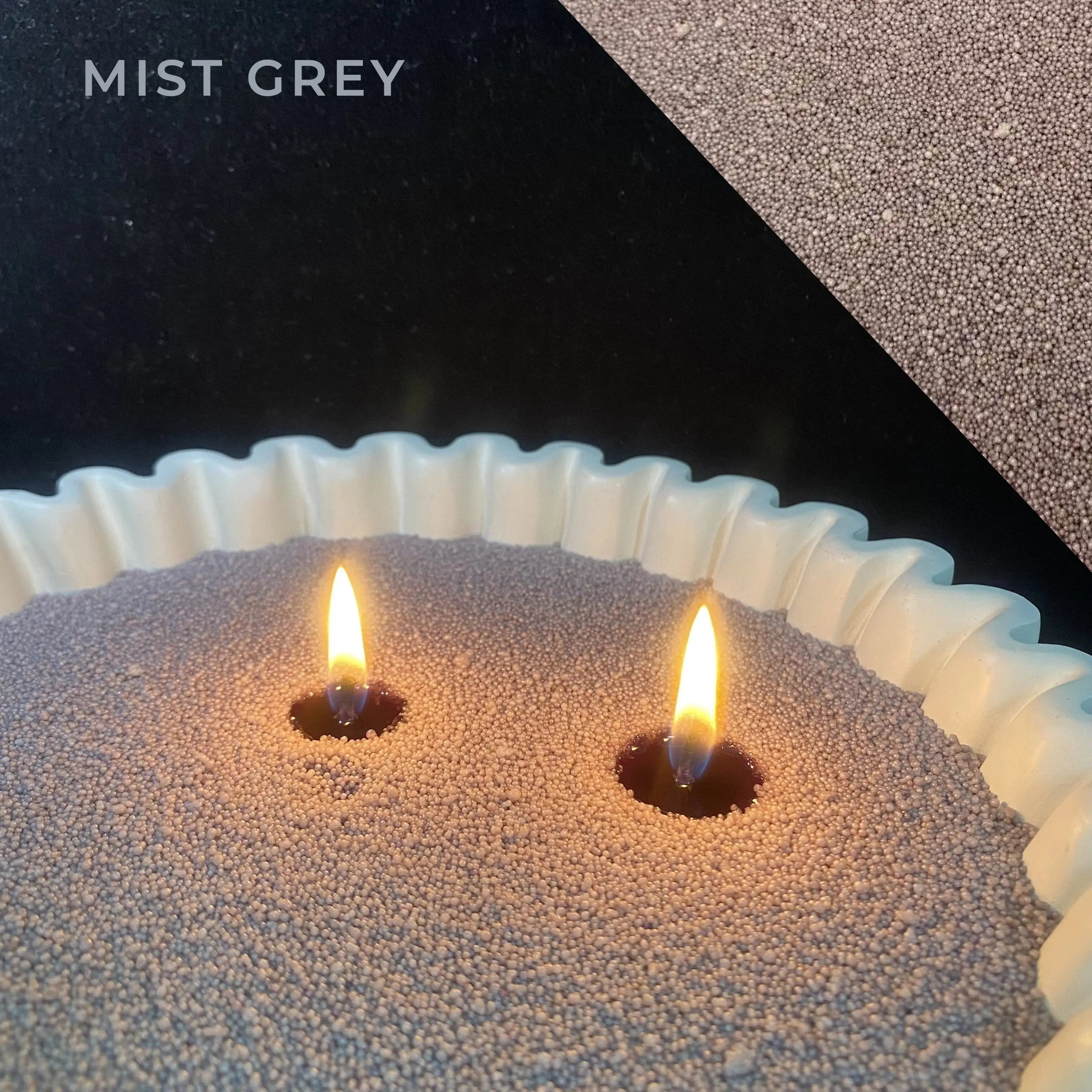 close-up of mist grey pearled candle wax with a clean flame and visible wax pearls
