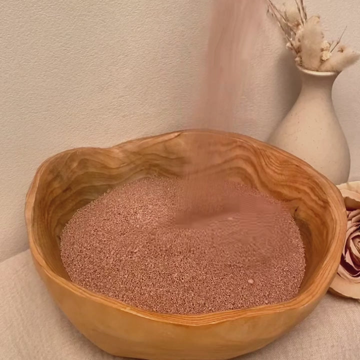 Warm Taupe pearled candle wax glowing in a gold vessel with soft warm light